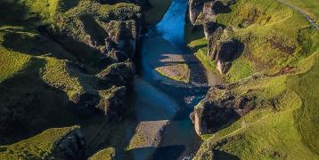 Bird view of river running through green mountains